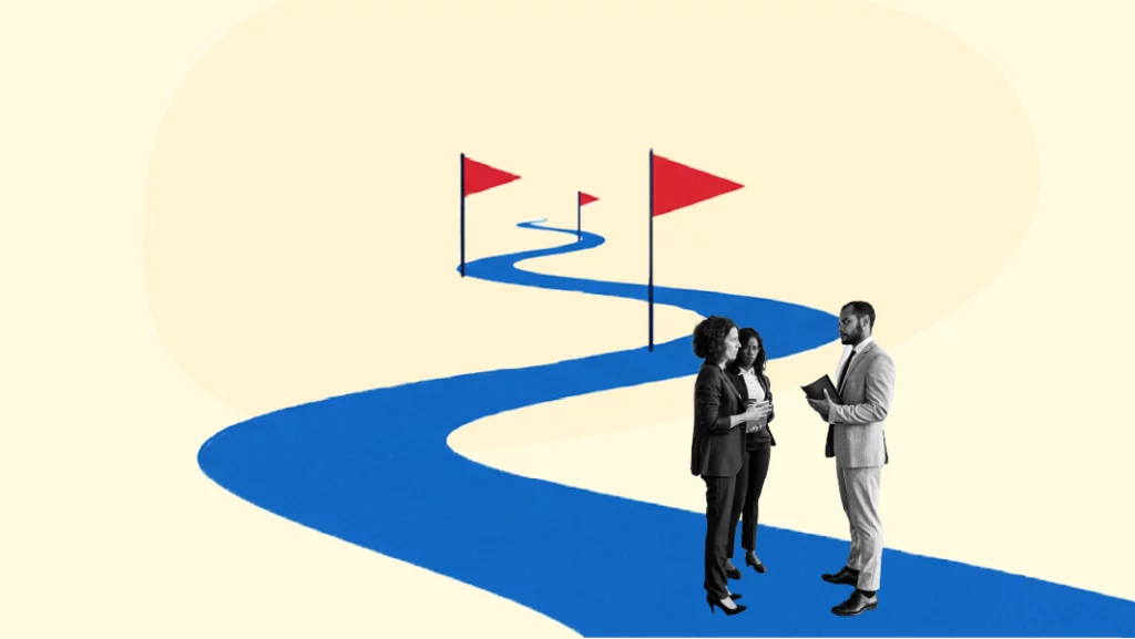 Three professionals discussing in front of a winding path marked with red flags, symbolizing a product roadmap journey.