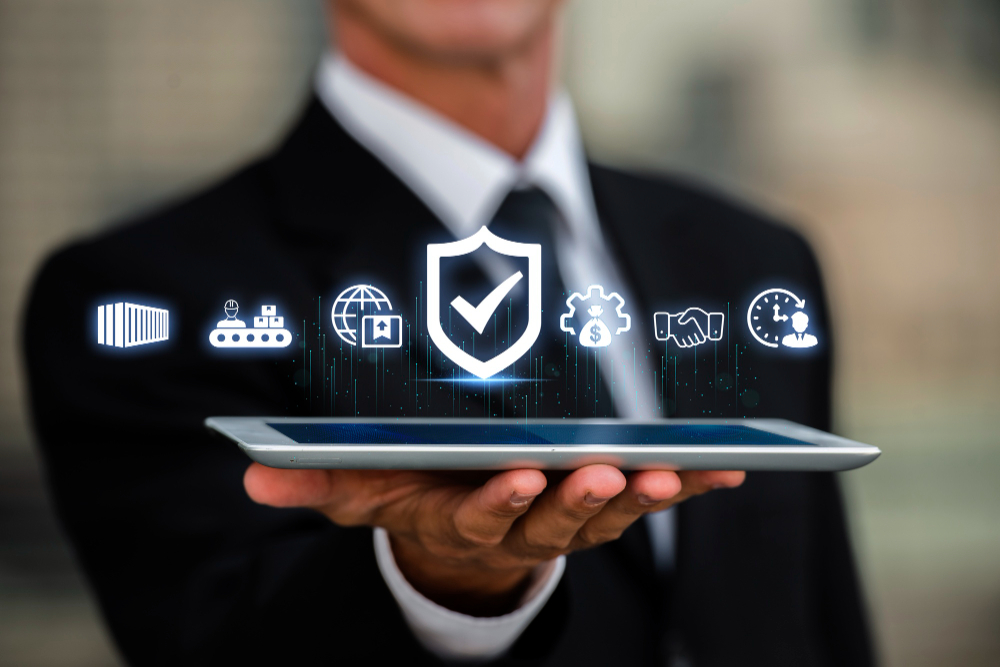 Business professional holding a tablet with digital icons representing fintech compliance, security, financial management, and global connectivity.