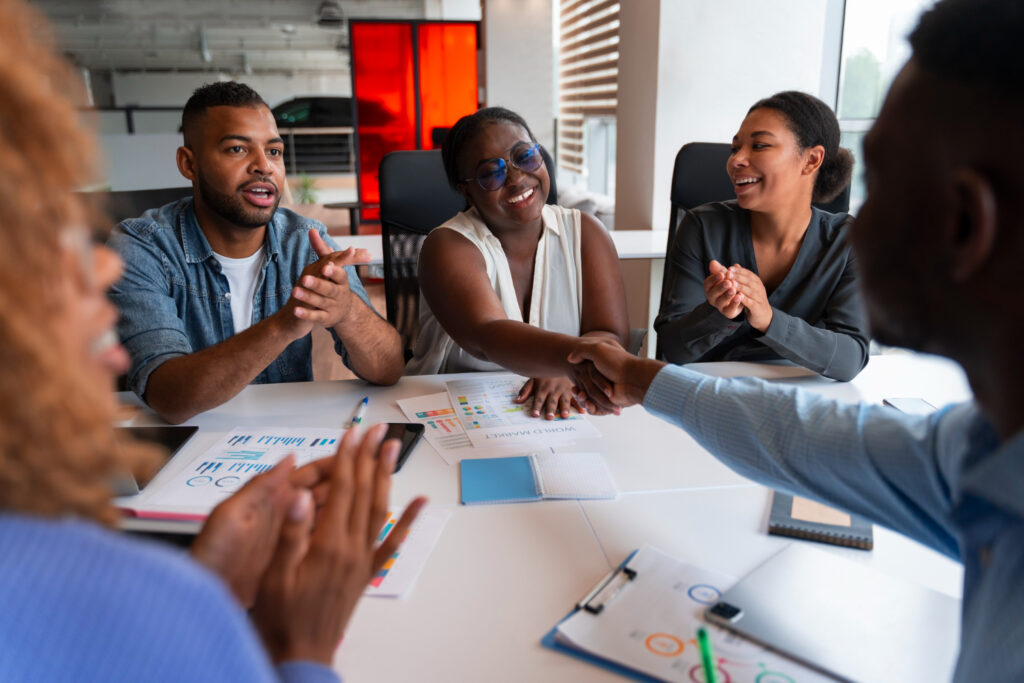 "A diverse team celebrating a new marketing manager's success during a strategy meeting — ideal for first-time product marketing managers."