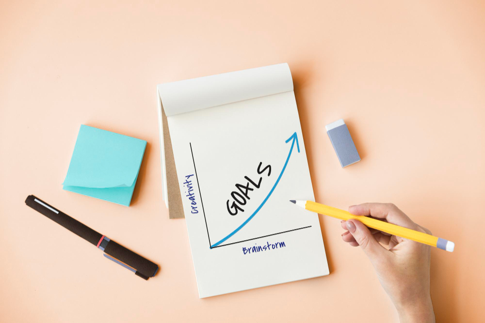 a notepad that has "goals" written on it to show Ebun's goal to get a Product Marketing Manager Role